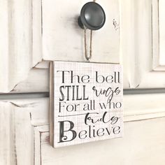 the bell still rings for all who fall asleep believe wood sign hanging on white door