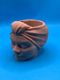 a clay sculpture of a man's head wearing a turban