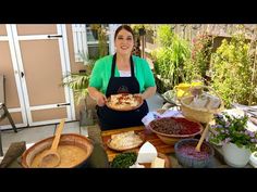 a woman in an apron holding a plate of food