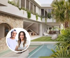 a man and woman standing in front of a house with a pool next to it