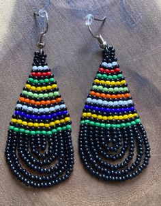 These handmade beaded earrings are truly unique. Each one is hand made with a rotating striped pattern. These earrings are available in a multitude of colors -making them perfect for any outfit! Whether it's dressing up a jean jacket or adding a unique texture to a LBD, there's no way you can go wrong with these earrings! We have given each design a name in honor of our favorite people! Please note that colors may vary a bit by pair as no two are exactly alike Handmade Casual Beaded Earrings, Casual Handmade Beaded Earrings, Casual Multicolor Dangle Beaded Earrings, Casual Multicolor Beaded Dangle Earrings, Casual Multicolor Earrings For Festivals, Casual Multicolor Festival Earrings, Multicolor Earrings With Black Beads For Gift, Multicolor Earrings With Black Beads, Multicolor Teardrop Casual Jewelry