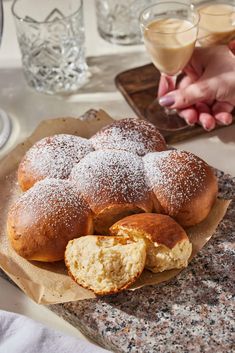 powdered sugar covered pastries on top of a table next to a glass of wine