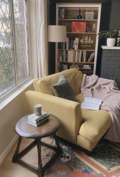 a living room with a couch, coffee table and bookshelf in the corner