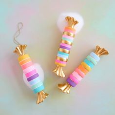 three different types of candy on a white table with gold trimmings and balloons