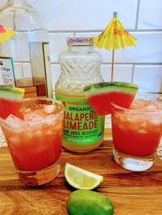 three glasses filled with watermelon and limeade next to a bottle of alcohol