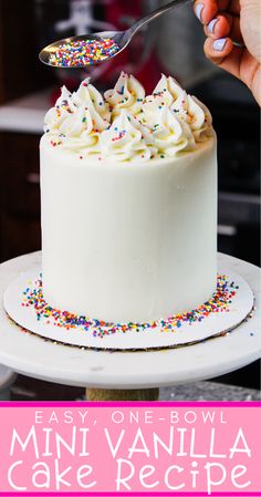 a cake with white frosting and sprinkles is being cut by a fork