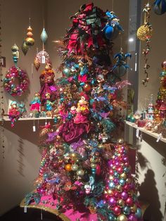 a brightly colored christmas tree with ornaments on it's sides and hanging from the ceiling