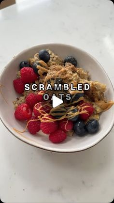 a bowl filled with cereal and berries on top of a table