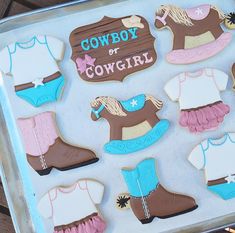 some decorated cookies in the shape of cowboy boots and horses are on a cookie sheet