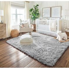 a baby's room with white walls and wooden flooring, teddy bears on the rug