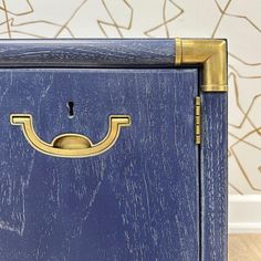 a blue cabinet with brass handles on it