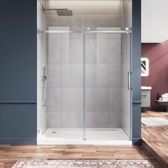 a walk in shower sitting on top of a wooden floor next to a white rug