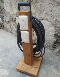 a wooden stand with two electrical cords attached to it