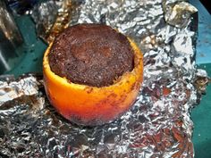 an orange that is sitting on some tin foil