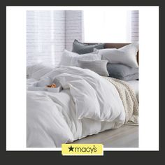 a bed with white sheets and pillows on it