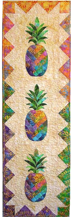 a quilted wall hanging with pineapples on it