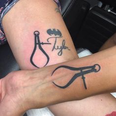 two people with tattoos on their legs sitting next to each other, one has scissors and the other has an umbrella