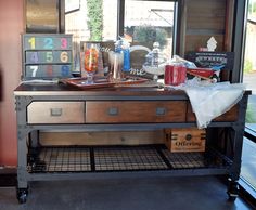 an old desk with lots of items on it in front of a large glass window