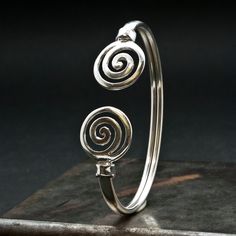 Unisex Spiral Cuff Sterling Silver Bracelet, Men/Women Greek Bracelet with Swirl, Men's Gift Bracelet, Greek Jewelry A handmade bracelet inspired by the ancient Greek spiral infinity symbol. A meaningful statement gift that is supposed to provide good luck and long life upon the wearer. Bangle bracelet width 5 mm approx. Made with soft 925 sterling silver so that may slightly expand/straightened Inner diameter 67 mm approx. Hallmarked 925 This is more of my Greek jewelry collection http://www.et Bohemian Spiral Cuff Bracelet Gift, Silver Spiral Cuff Bracelet Gift, Symbolic Adjustable Spiral Jewelry, Adjustable Symbolic Spiral Jewelry, Elegant Spiral Metal Cuff Bracelet, Adjustable Spiral Silver Cuff Bracelet, Adjustable Silver Spiral Cuff Bracelet, Adjustable Metal Spiral Cuff Bracelet, Art Necklaces