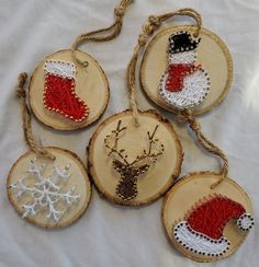 four wood slices decorated with christmas stockings and snowflakes, hanging from twine