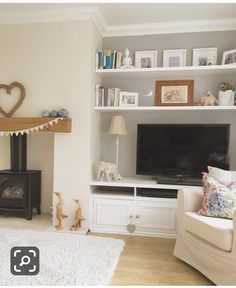 a living room filled with furniture and a flat screen tv on top of a fireplace