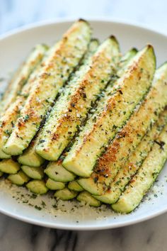 baked parmesan zucchini on a white plate with the title above it