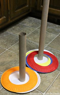 two paper plates on the floor with poles sticking out of them