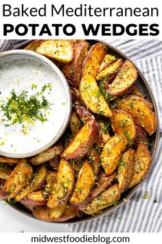 a plate filled with potato wedges next to a bowl of ranch dressing