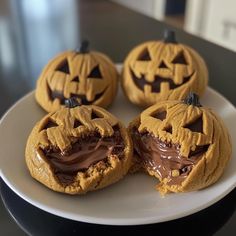 four pumpkin shaped cookies on a white plate