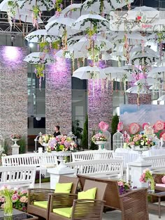 an outdoor event with tables, chairs and umbrellas hanging from the ceiling