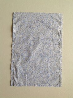 a piece of cloth with blue and white flowers on it sitting on a beige surface