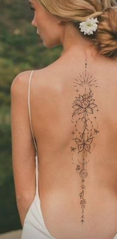 the back of a woman's body with tattoos on her upper and lower back