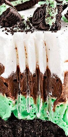 an ice cream cake with oreo cookies and green frosting on it's top