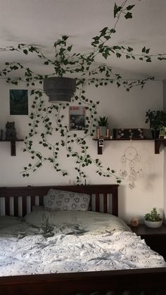 there is a bed with plants growing on the wall above it, and other decorations