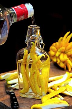 a bottle filled with liquid sitting on top of a table next to cut up bananas