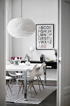 a dining room table with chairs and a white rug