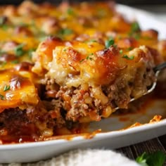 a casserole dish with meat, cheese and sauce in it on a white plate