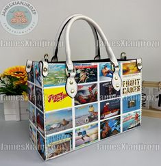 a handbag with pictures on it sitting next to a vase filled with yellow flowers