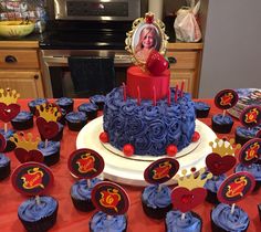 a birthday cake and cupcakes on a red tablecloth with a photo of a woman