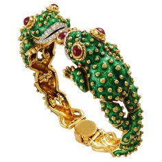 A 1960's David Webb frog bracelet, designed as an articulated hinged bangle modeled as two textured green enamel facing frogs with circular-cut diamond stylized lips and cabochon ruby eyes, with each gold-spotted body forming the remaining bracelet. Finished at the top and clasp by a cabochon ruby-set collet. The bracelet is crafted in 18k gold & platinum, and is signed David Webb. inner circumference approx. 6 1/2" Frog Bracelet, Cabochon Ruby, Frog Jewelry, Diana Vreeland, David Webb, The Bangles, Diamond Bangle, Elizabeth Taylor, Green Enamel