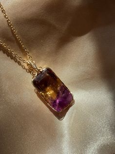 As a stone of both balance and connection, ametrine is believed to relieve tension, bring serenity and stimulate creativity, as well as balance mental stability and self-confidence. Hand Wrapped Amethyst Crystal Necklace For Gift, Gold Amethyst Crystal Necklace For Healing, Gold Amethyst Gemstones For Healing, Rectangular Purple Amethyst Necklaces, Purple Rectangular Amethyst Necklaces, Healing Jewelry With Natural Rectangular Stones, Spiritual Fluorite Gemstone Crystal Necklace, Natural Stones Rectangular Healing Jewelry, Purple Rectangular Amethyst Necklace