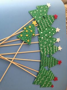 green christmas tree lollipop sticks on a blue plate with red and white stars