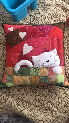 a cat is laying on top of a pillow with hearts in the shape of a heart