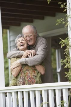 an older couple embracing each other on the porch