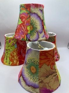 four lampshades with different designs on them sitting next to each other in front of a white background