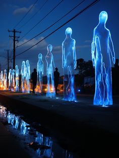 an image of people standing in the street at night with blue lights on their bodies