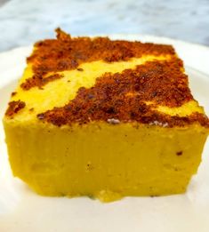 a piece of yellow cake sitting on top of a white plate