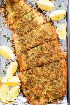 fish fillets with lemon slices and parmesan cheese on a sheet of tin foil