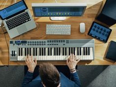 a man sitting at a desk playing an electronic keyboard