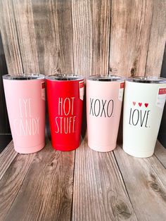 three different colored tumblers sitting next to each other on a wooden table with the words i love my candy written on them